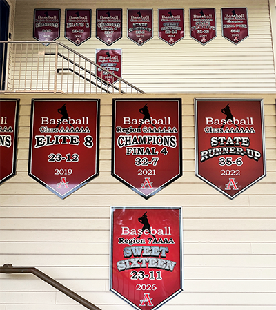 Custom aluminum baseball championship banners installed at Allatoona High School, including the newest state tournament achievement alongside previous seasons.