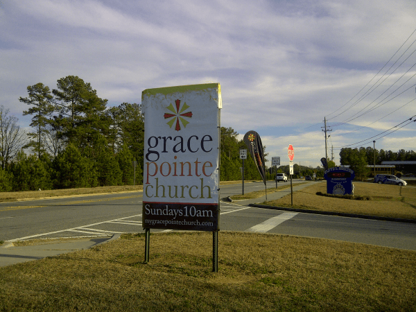 Church Places Pillowcase Banner over School Sign on weekends only to announce Services