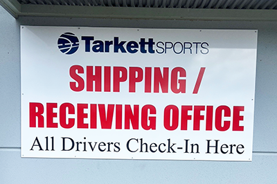 Custom aluminum shipping and receiving office sign for Tarkett Sports in Adairsville, Georgia, directing truck drivers to the designated check-in location.