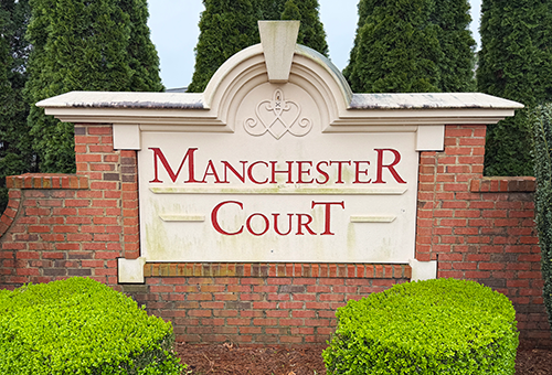 weathered and damaged neighborhood monument sign before repair in Cumming, Georgia