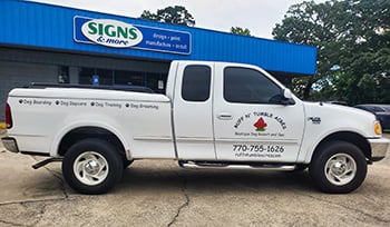 White Ford F-150 with custom Ruff N’ Tumble Acres business decals installed by Signs &amp; More, featuring the company logo, services, phone number, and website.