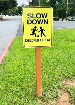 Yellow slow down children at play sign beside neighborhood road